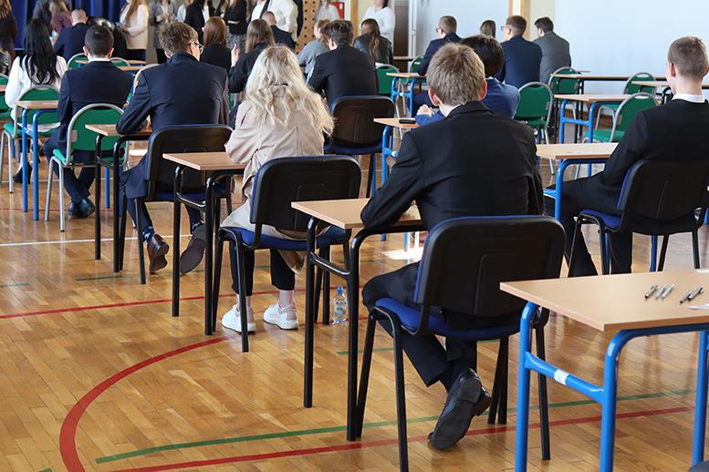  Pobrane Egzamin maturalny szkolny - uczniowie siedzący w ławkach 