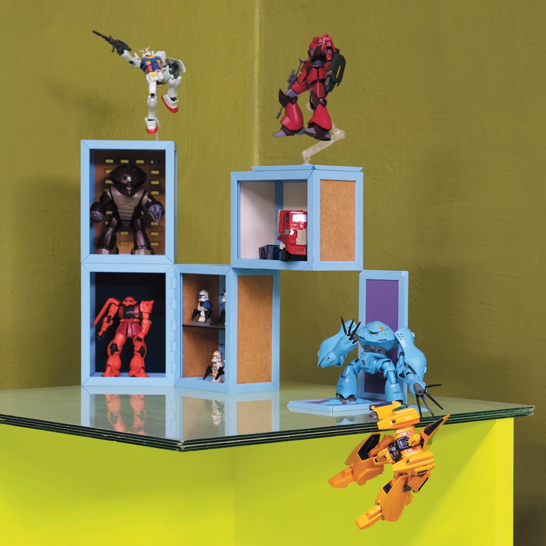 Kolekcja figurek robotów na jasnoniebieskich i żółto-zielonych półkach