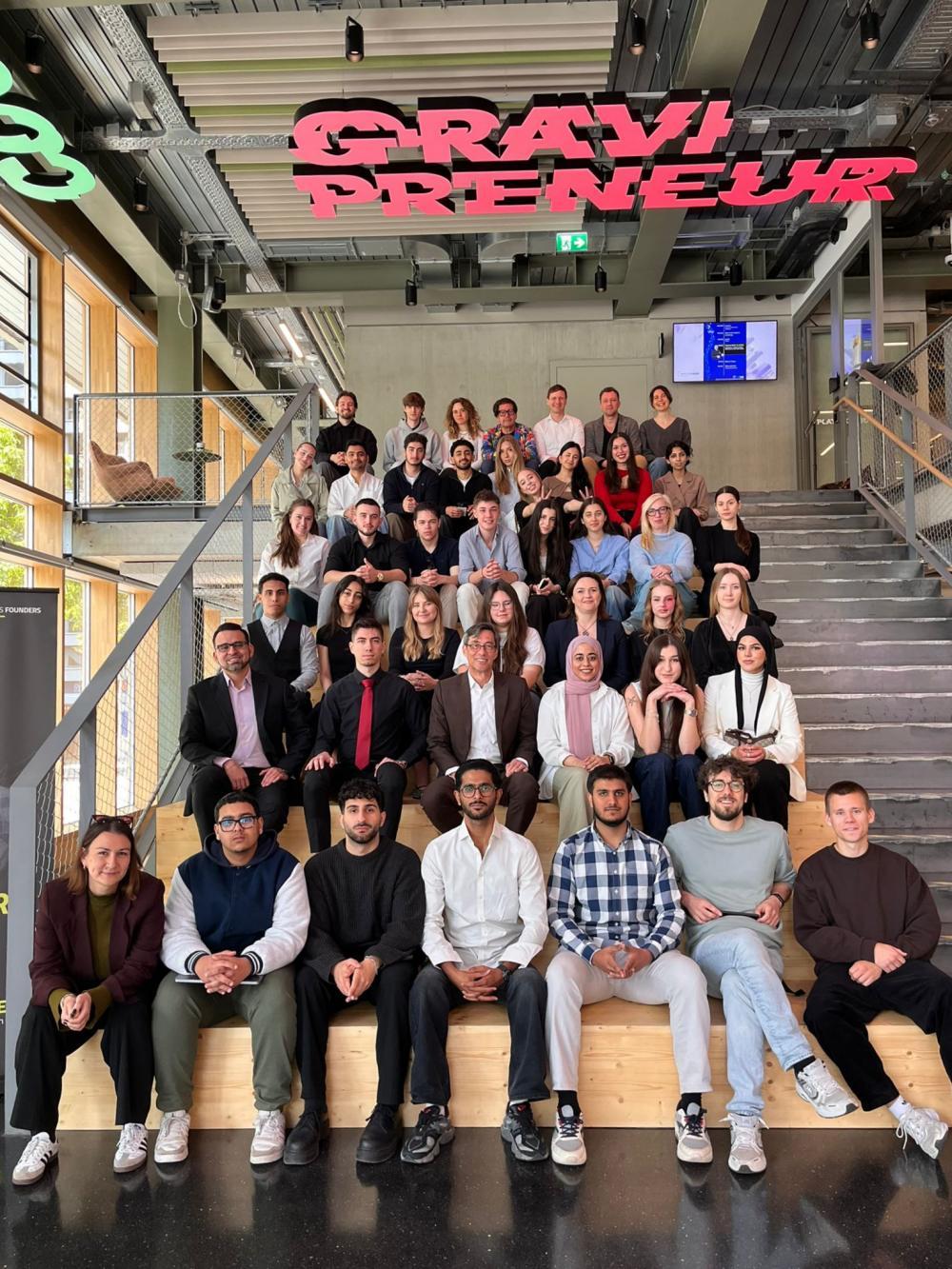 Studenci międzynarodowi siedzą na schodach w Campus Founders Hailbronn w Niemczech