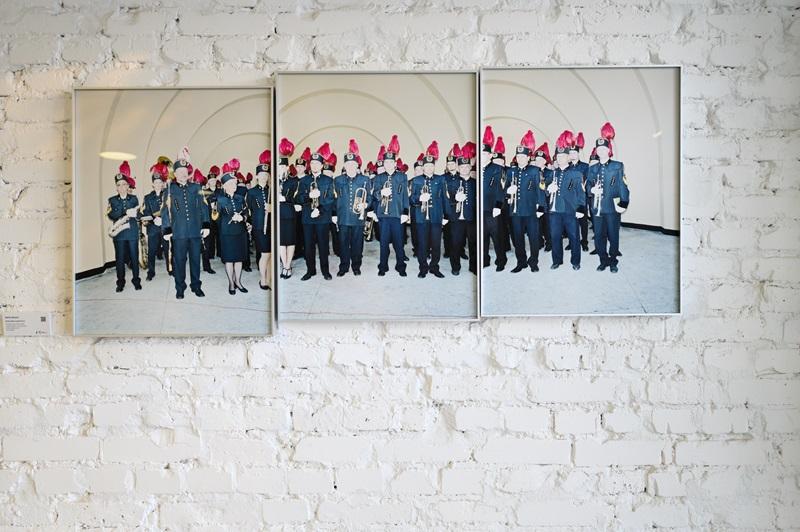 Fotografia autorstwa Rafała Milacha, przedstawiająca dużą grupę ubranych na galowo górników w czapkach z czerwonymi piórami.