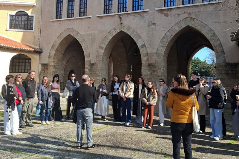 Uczestnicy seminarium wyjazdowego uczą się o architekturze na wyspie Rodos podczas warsztatu specerowego