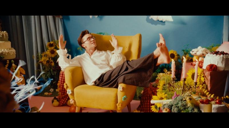 Kadr ze spotu reklamowego; Rozkoszny półleży na fotelu w bajkowej scenerii