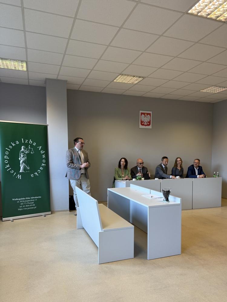 Jury konkursu siedzi za biurkiem.