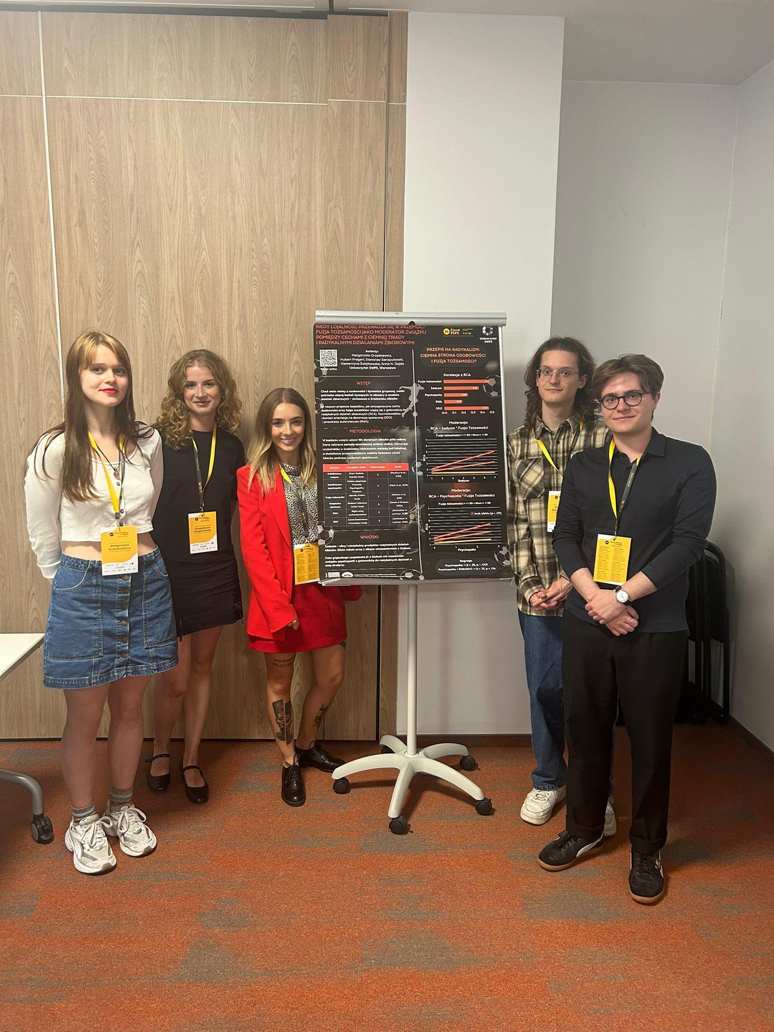 Studenci i studentki USWPS prezentujący plakat naukowy na temat środowiska kibiców piłki nożnej