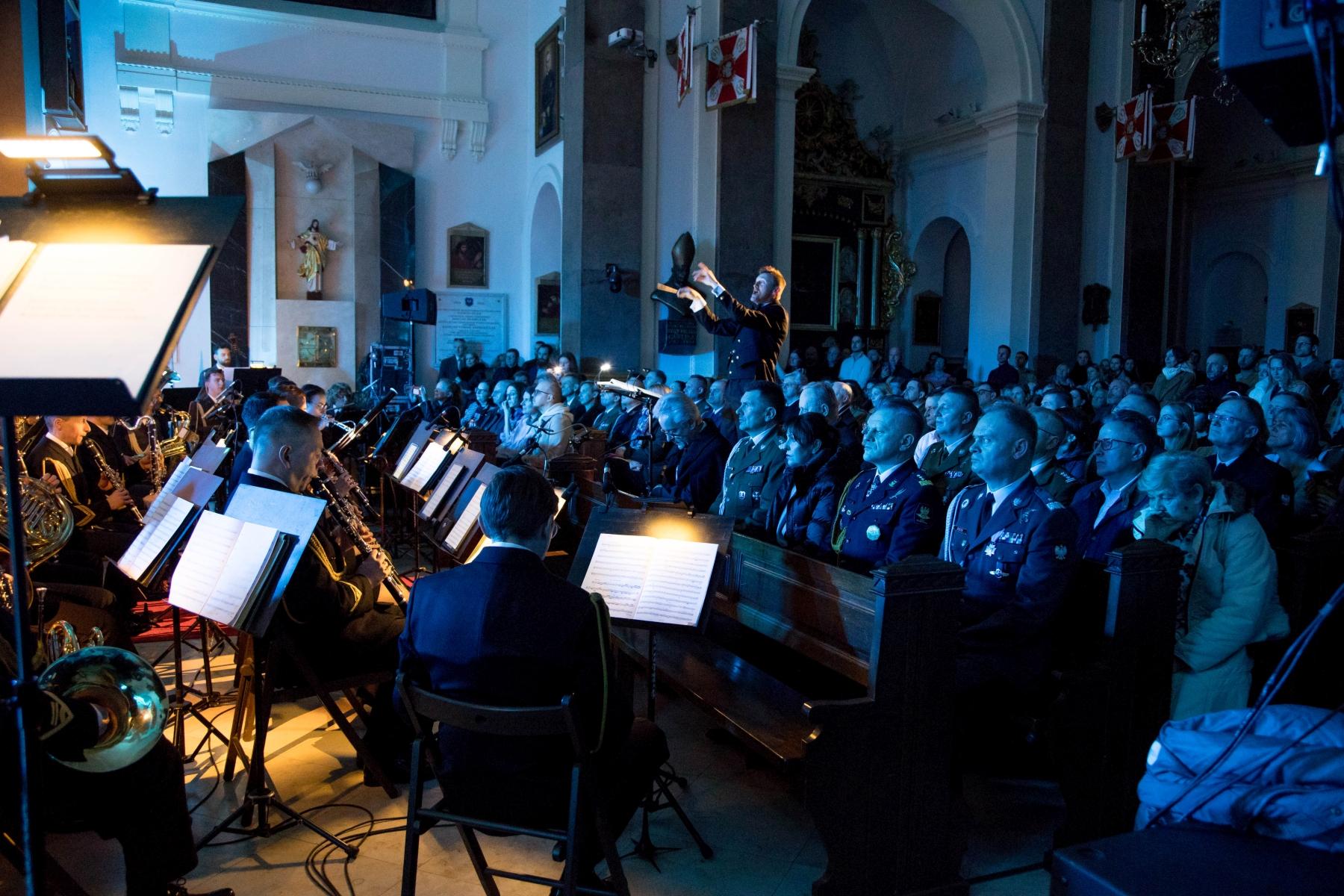 Koncert Chóru Akademickiego Uniwersytetu SWPS w Katedrze Polowej Wojska Polskiego. Członkowie orkiestry, publiczność i dyrygent w trakcie koncertu