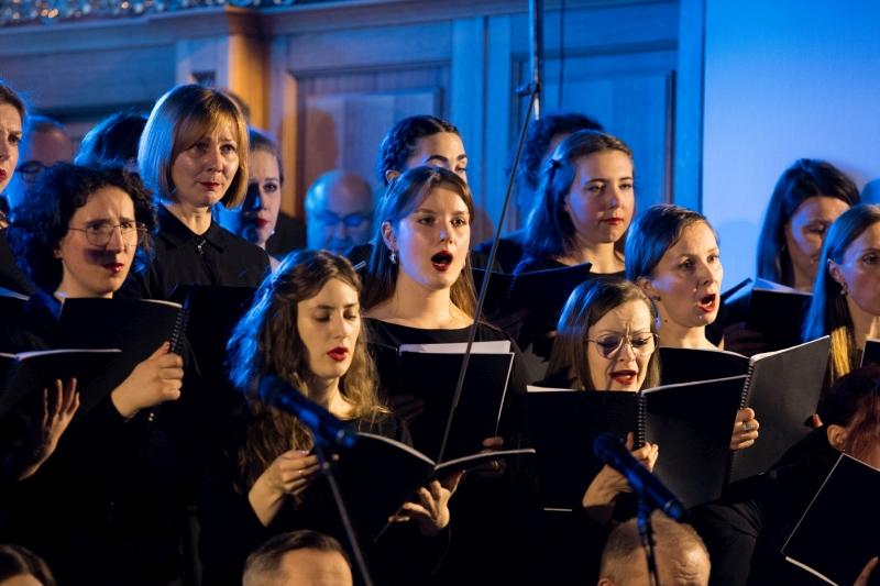 Koncert Chóru Akademickiego Uniwersytetu SWPS w Katedrze Polowej Wojska Polskiego. Chórzystki z USWPS śpiewają, trzymając partytury chóralne