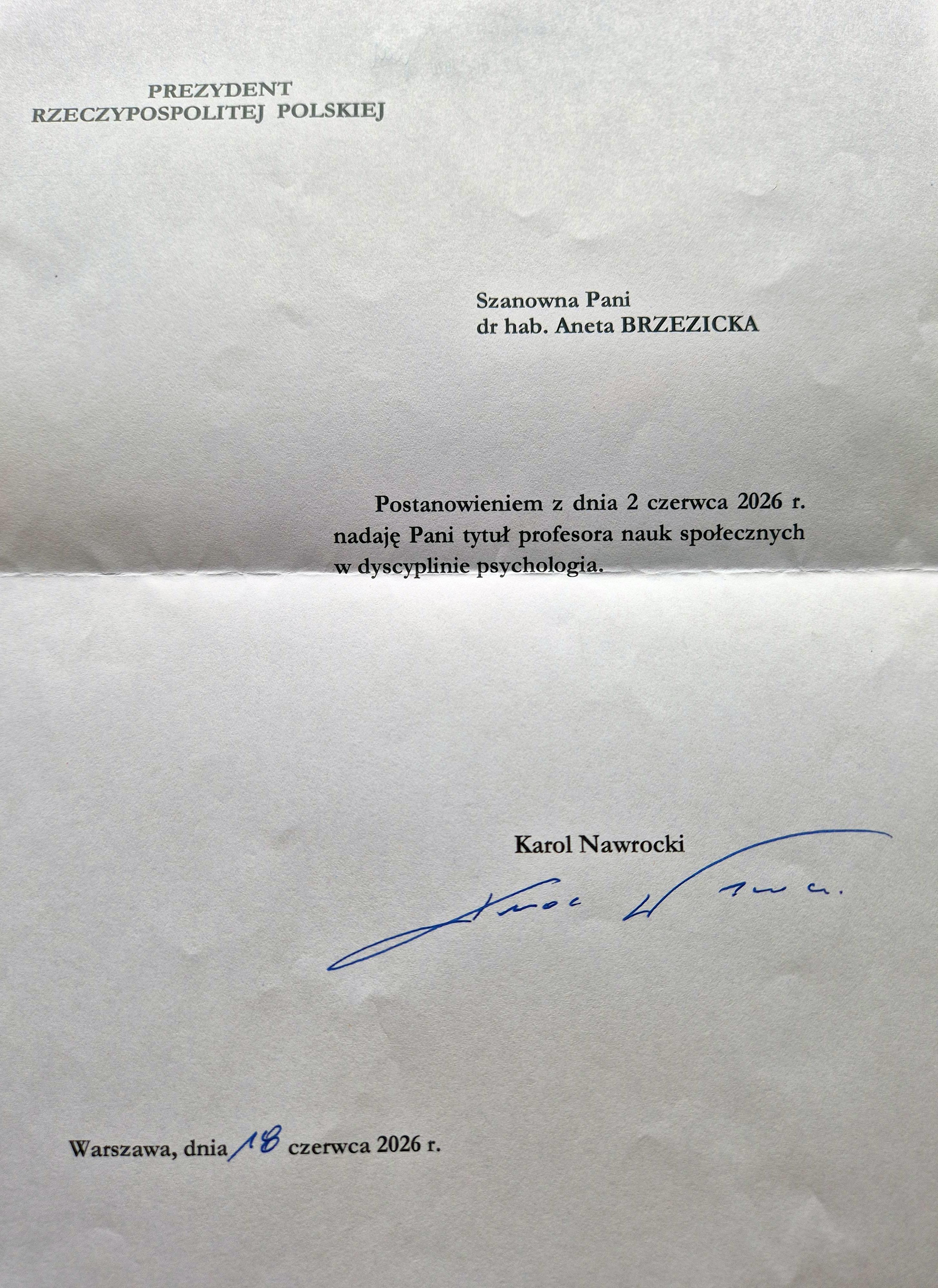 Zdjęcie listu o treści: „Prezydent Rzeczypospolitej Polskiej. Szanowna Pani dr hab. Aneta BRZEZICKA. Postanowieniem z dnia 2 czerwca 2026 r. nadaję Pani tytuł profesora nauk społecznych w dyscyplinie psychologia”. Poniżej podpis prezydenta Karola Nawrockiego i data 18 czerwca 2026 r.