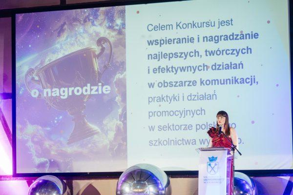 Gala Nagrody Stowarzyszenia PRom 2026. Kobieta przemawia z mównicy z logiem Uniwersytetu Jagiellońskiego. W tle slajd informujący o celu konkursu