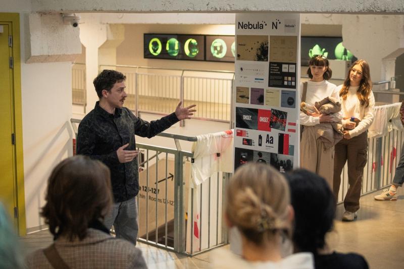 Grupka młodych ludzi podczas oprowadzania po wystawie Pomiędzy 23